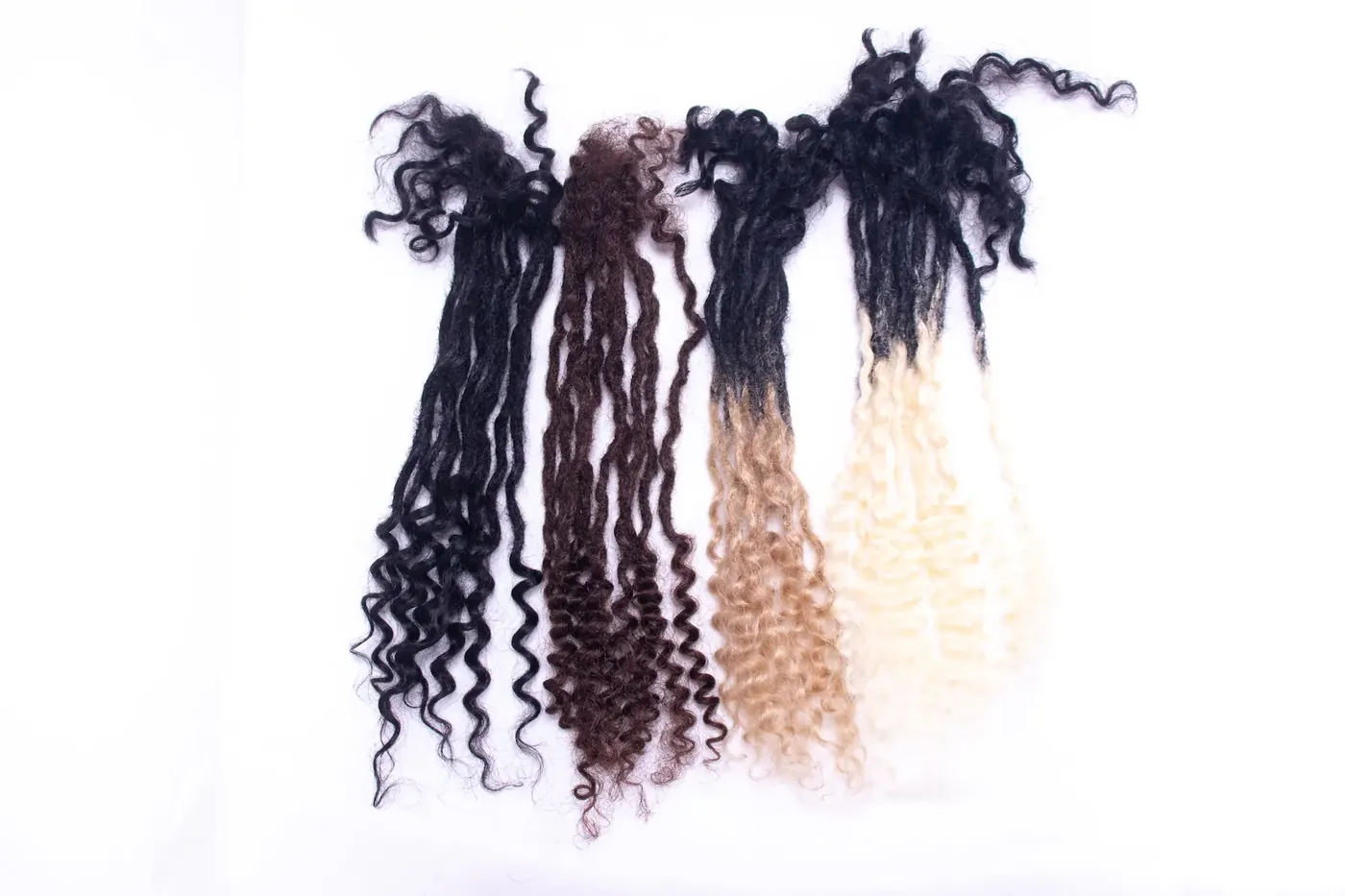 Four bundles of curly-ended loc extensions in black, brown, black-to-honey and black-to-platinum