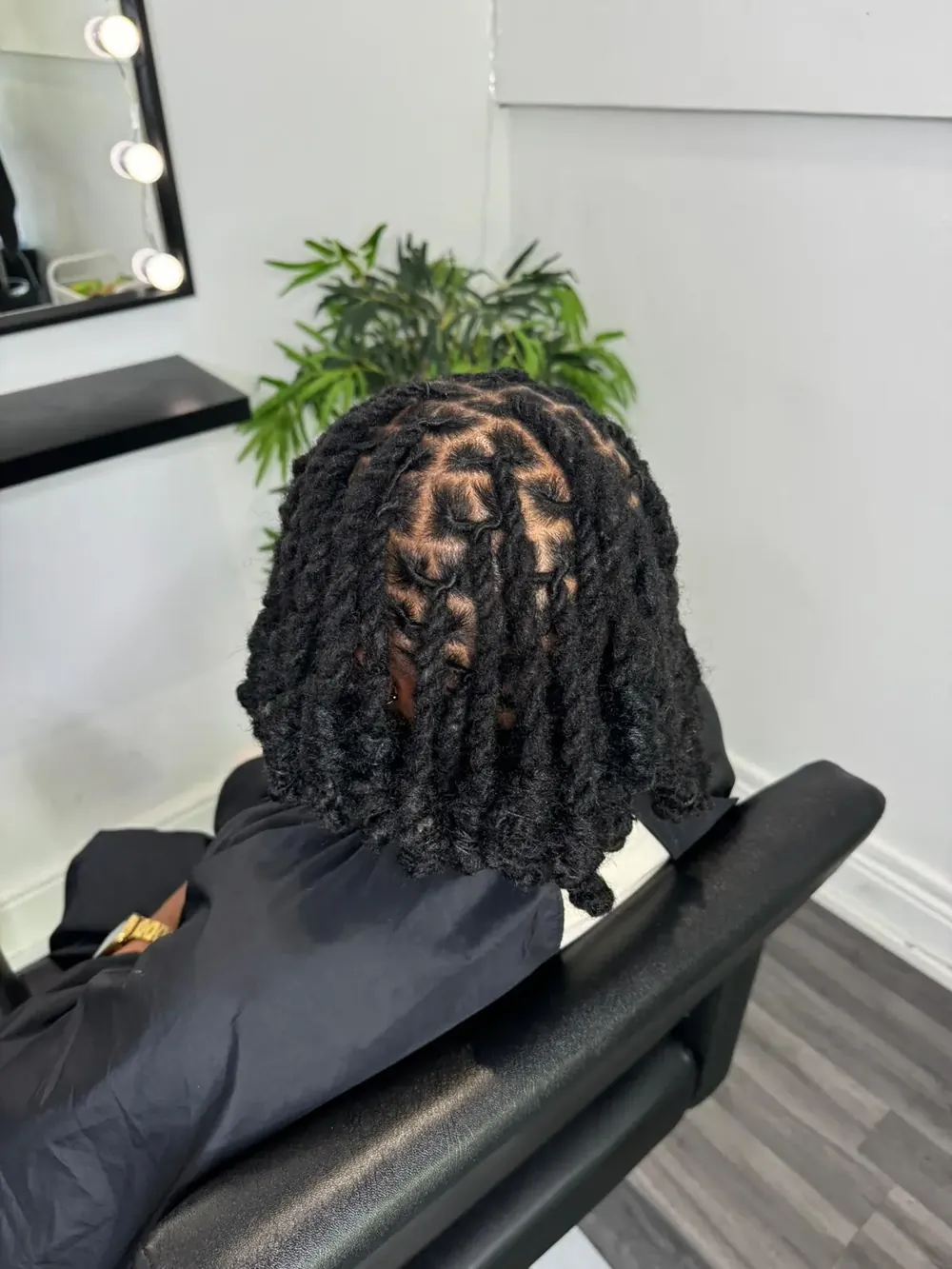 Freshly retwisted mature locs from behind, in The LocPod studio chair